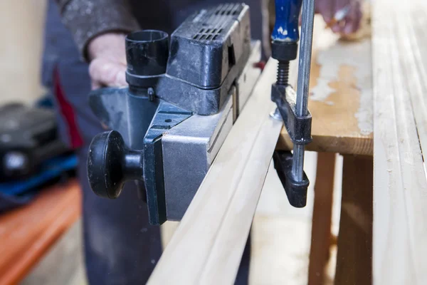 Carpenter using electric plane — Stock Photo, Image