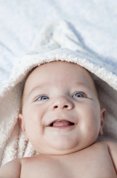 Smilling chlapeček zabalené osušku po koupeli v posteli doma — Stock fotografie