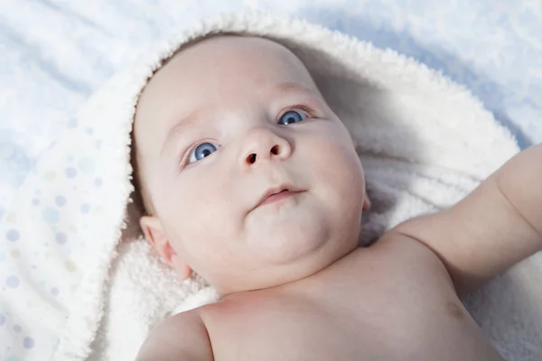 Feliz bebé niño envuelto toalla de baño después del baño en la cama en casa —  Fotos de Stock