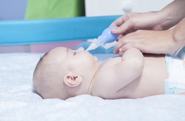 Mãe usando aspirador nasal de bebê — Fotografia de Stock