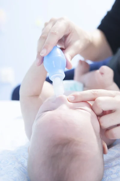 Mère utilisant un aspirateur nasal pour bébé — Photo