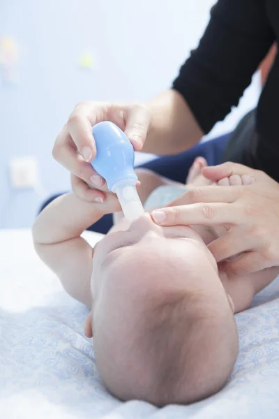 Mère utilisant un aspirateur nasal pour bébé — Photo