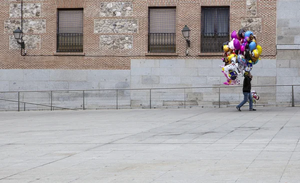 Venditore di palloncini non identificato cammina per la vecchia strada cittadina di Madrid — Foto Stock