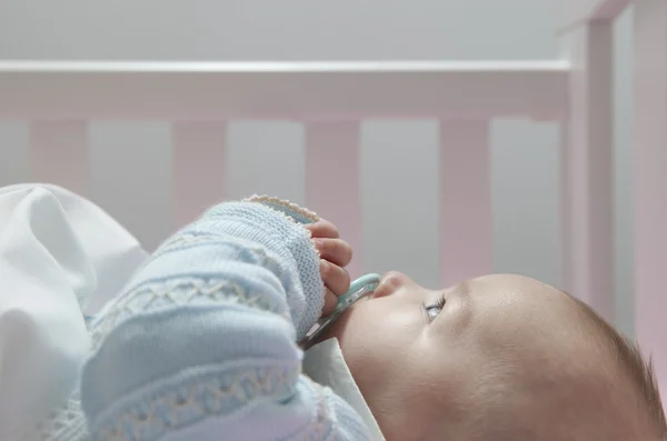 Wachsamer vier Monate alter Junge liegt mit Schnuller im Kinderbett — Stockfoto