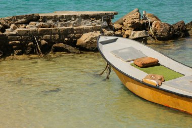 Harabe bir iskeleye bağlanmış terk edilmiş eski bir tekne.