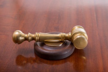 Antika bronz yargıç tokmağı. Süslenmiş maun ağacından bir masa üzerinde.