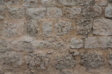 Çiğ mermer ve kireç taşıyla eski bir evin duvarı.