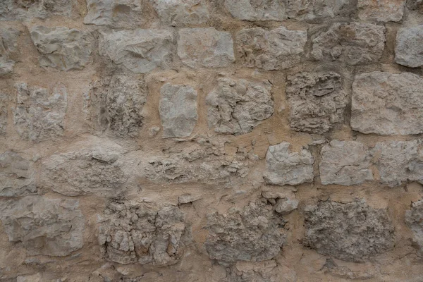 Çiğ mermer ve kireç taşıyla eski bir evin duvarı.