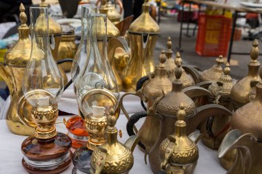 Pazar caddesinde modern tip gazyağı lambaları ve sıcak içecekler için bronz sürahiler satılıyor.