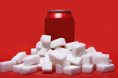 cola refreshing drink can and lot of white sugar cubes representing the big amount of calories