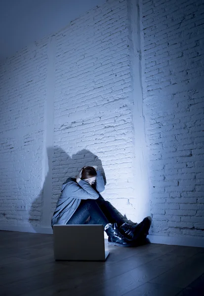 Scared female teenager with computer laptop suffering cyberbullying and harassment being online abused — Stock Photo, Image