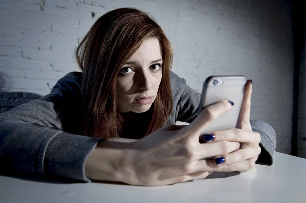 Young sad vulnerable girl using mobile phone scared and desperate suffering online abuse cyberbullying — Stock Photo, Image