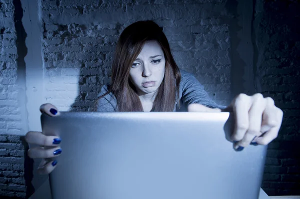 Scared female teenager with computer laptop suffering cyberbullying and harassment being online abused — Stock Photo, Image