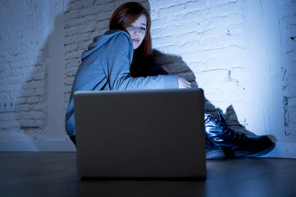 Scared female teenager with computer laptop suffering cyberbullying and harassment being online abused — Stock Photo, Image