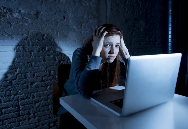 Scared female teenager with computer laptop suffering cyberbullying and harassment being online abused — Stock Photo, Image