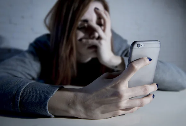 Young sad vulnerable girl using mobile phone scared and desperat — Stock Photo, Image