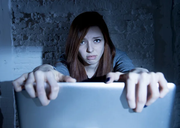 Scared female teenager with computer laptop suffering cyberbullying and harassment being online abused — Stock Photo, Image