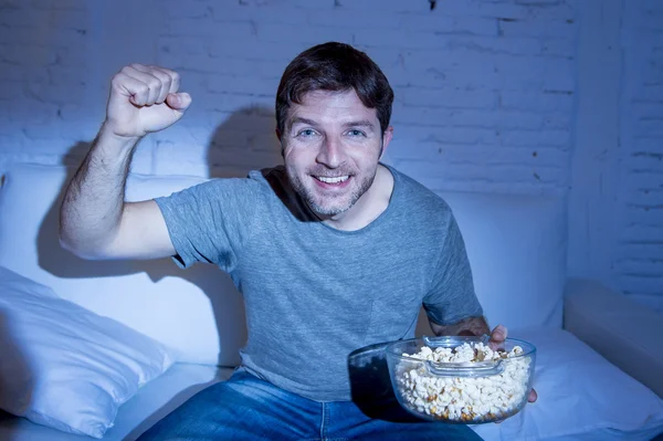 Junger glücklicher Mann zu Hause sieht Sportspiel im Fernsehen und jubelt seinem Team zu, das mit der Siegerfaust gestikuliert — Stockfoto