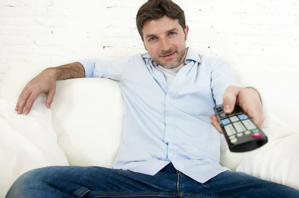 Joven feliz hombre viendo tv sentado en casa sala de estar sofá buscando relajado disfrutando de la televisión —  Fotos de Stock