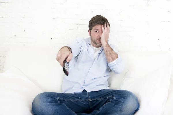 Joven feliz hombre viendo televisión horror película cubriendo sus ojos asustado y horrorizado — Foto de Stock