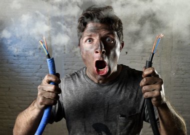 untrained man joining electrical cable suffering electrical accident with dirty burnt face in funny shock expression