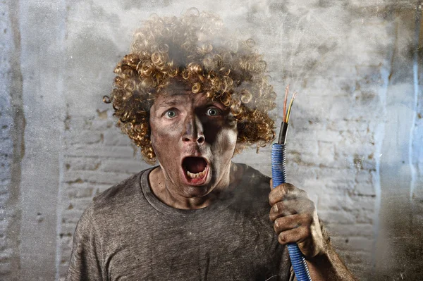 Man with cable smoking after domestic accident with dirty burnt face shock electrocuted expression — Zdjęcie stockowe