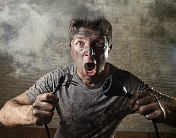 Cable de hombre no entrenado que sufre accidente eléctrico con la cara quemada sucia en expresión de choque divertido —  Fotos de Stock