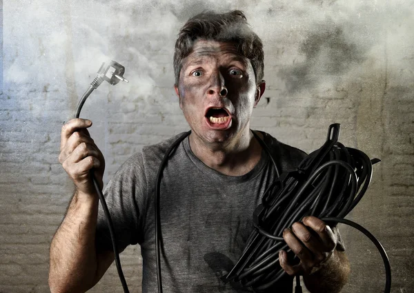 Untrained man cable suffering electrical accident with dirty burnt face in funny shock expression — Zdjęcie stockowe