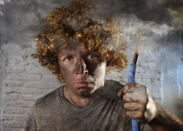 Man with cable smoking after domestic accident with dirty burnt face shock electrocuted expression — Stock Photo, Image