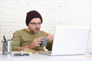 young attractive hipster businessman working from his home office as freelancer self employed business model