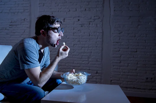 Adicto a la televisión hombre en el sofá viendo la televisión y comer palomitas de maíz en divertidos nerd geek gafas — Foto de Stock