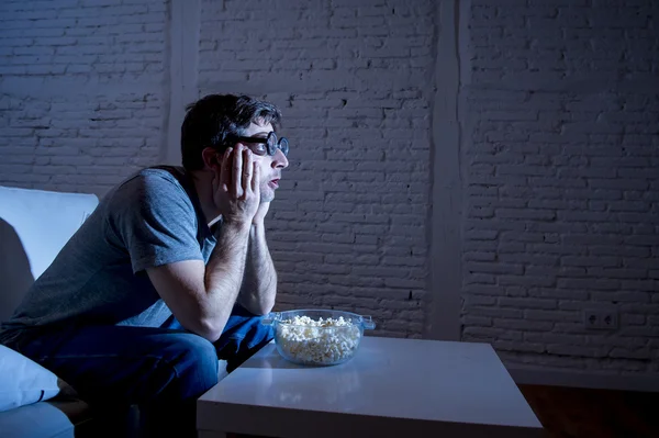 Telewizja uzależniony człowiek na kanapie oglądania telewizji i jedzenia popcorn w zabawny Nerd Geek okulary — Zdjęcie stockowe