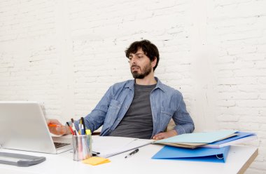 Genç İspanyol hippi iş adamı bilgisayar bürosunda çalışıyor.