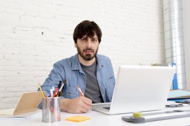 Genç İspanyol hippi iş adamı bilgisayar bürosunda çalışıyor.