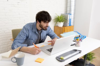 Genç İspanyol hippi iş adamı bilgisayar bürosunda çalışıyor.