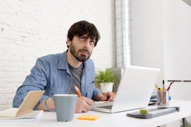 Genç İspanyol hippi iş adamı bilgisayar bürosunda çalışıyor.