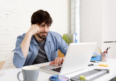 Genç İspanyol hippi iş adamı bilgisayar bürosunda çalışıyor.