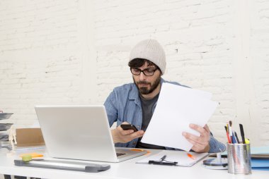  Cep telefonu kullanarak ev ofisinde çalışan İspanyol çekici hipster işadamı