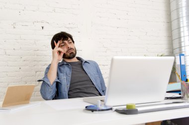 Genç İspanyol hippi iş adamı bilgisayar bürosunda çalışıyor.