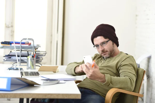 Giovane attraente uomo d'affari hipster che lavora da casa ufficio con il telefono cellulare — Foto Stock