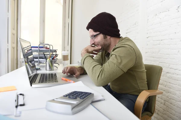Joven atractivo hipster hombre de negocios que trabaja con la computadora en la oficina en casa moderna — Foto de Stock
