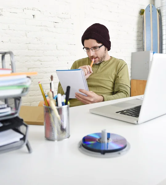 Young hipster businessman working with computer in home office as creative freelancer — Stockfoto