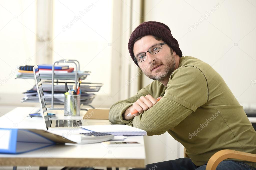 happy attractive hipster businessman working with computer laptop at home office