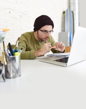 young hipster businessman working with computer in home office as creative freelancer 