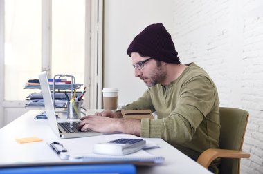 young attractive hipster businessman working from his home office as freelancer self employed business model