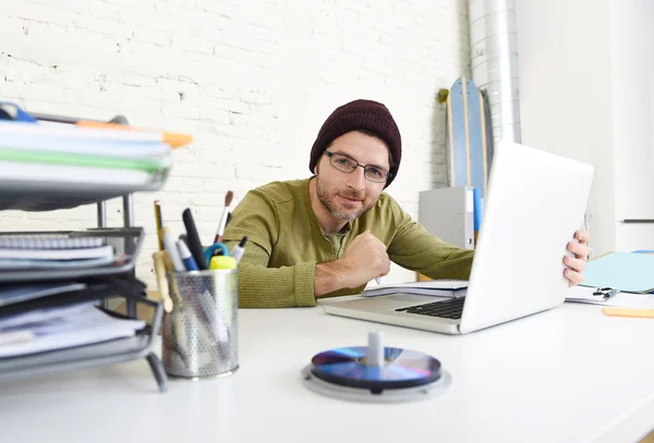 Молодой хипстерский бизнесмен, работающий с компьютером в домашнем офисе в качестве креативного фрилансера — стоковое фото