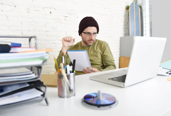 Young hipster businessman working with computer in home office as creative freelancer — Zdjęcie stockowe