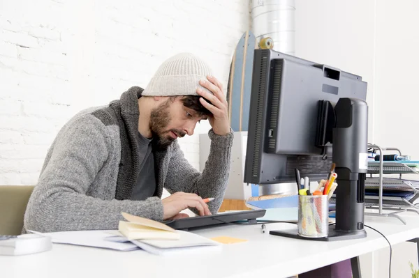 Молодой обеспокоенный бизнесмен в прохладной хипстерской шапке выглядит отчаянно имея проблемы с работой в стрессе — стоковое фото