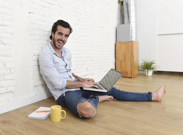 Young man in hipster modern casual style look sitting on living room home floor working on laptop — Zdjęcie stockowe