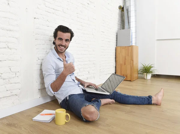 Young man in hipster modern casual style look sitting on living room home floor working on laptop — Zdjęcie stockowe